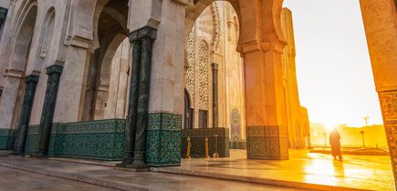 Eine Moschee mit einem hohen Minarett bei Sonnenuntergang.