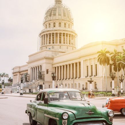 Ein grüner Oldtimer vor dem Capitolio in Havanna.