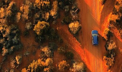 Auto fährt durch die rote Landschaft Australiens