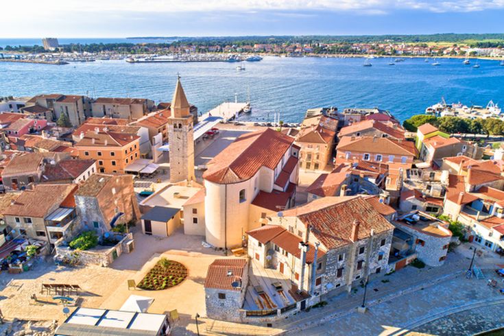 Eine Luftaufnahme der historischen Stadt Umag, Kroatien, mit roten Dächern und Blick auf das Meer.