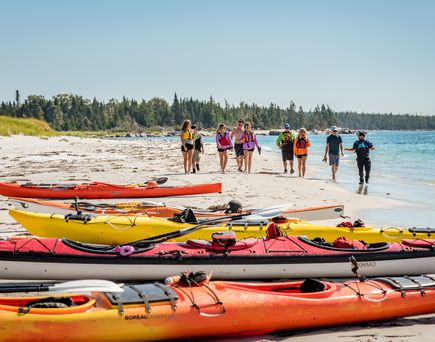 Eine Gruppe Menschen geht am Küstenabschnitt Keji Seaside auf Kajaks zu