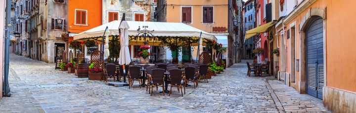 Ein Café in Rovinj mit Tischen und Stühlen.