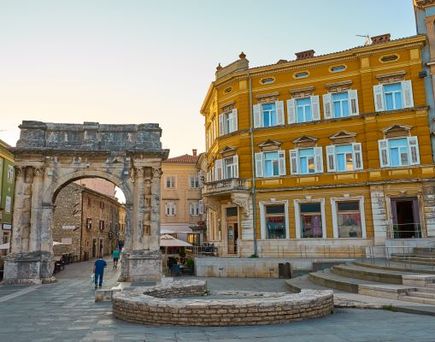 Ein Stadtplatz in Pula, Kroatien, mit historischen Gebäuden.