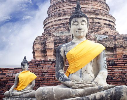 Steinerne Buddhas vor Tempelruinen in der Königsstadt Ayutthaya