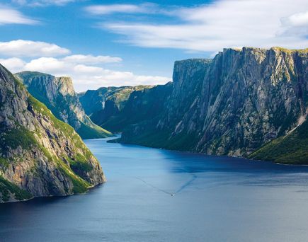 Zu sehen ist das western Brook Pond Fjord, links und rechts grüne Hügel und Berge, geteilt durch das Wasser.
