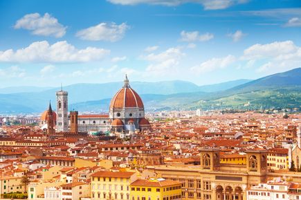 Ein weiter Blick über Florenz mit seiner Kathedrale bei strahlend blauem Himmel. Lediglich eine kleine Wolke zu sehen.