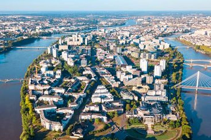 Eine Luftaufnahme einer Stadt mit einem Fluss und einem Schloss.