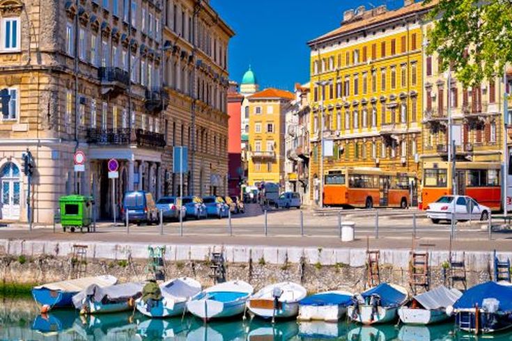 Eine Stadtansicht mit Gebäuden, die sich im Wasser spiegeln, und Booten.