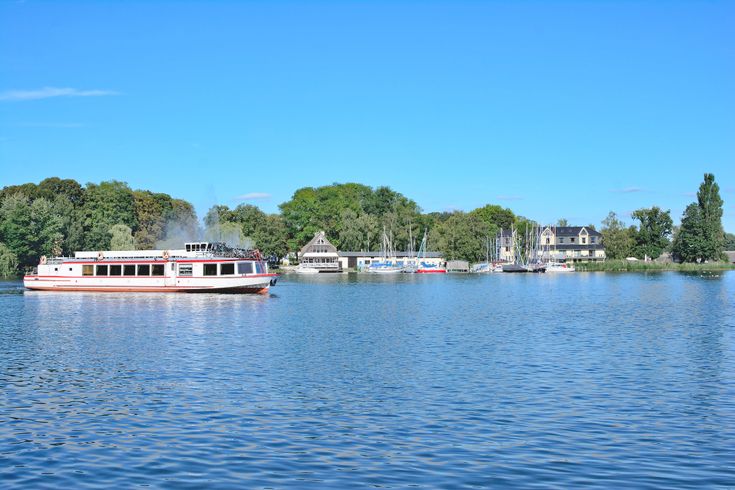 Eine Promenade am Müritzsee in Röbel mit Booten und Gebäuden am Ufer.