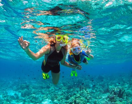 Mutter und tochter tauchen im türkisblauen Wasser.