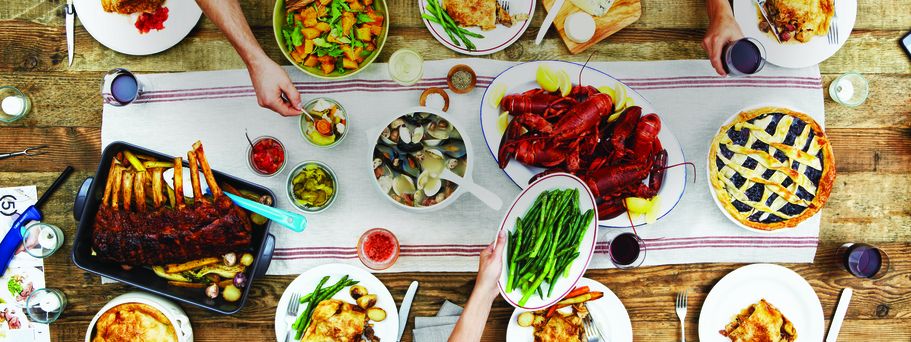Tisch mit Speisen wie Lobster und Bohnen, die Teller sind gedeckt