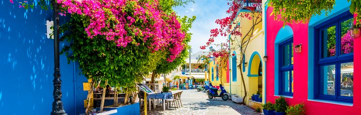 Eine enge Gasse mit bunten Gebäuden und Blumen.