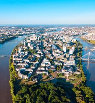 Eine Luftaufnahme einer Stadt mit einem Fluss und einem Schloss.