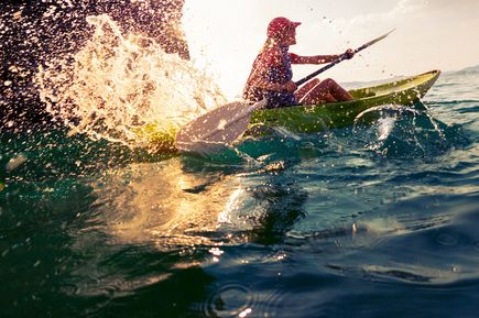 Eine Person in einem Kajak auf dem Wasser.