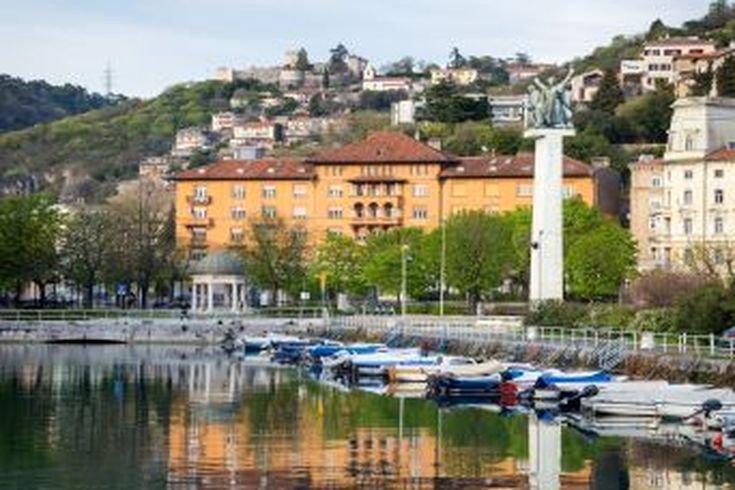 Eine Stadtansicht mit roten Dächern und Blick auf das Meer.