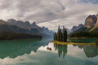 Ein gelbes Kanu vor einer kleinen Insel im Maligne Lake