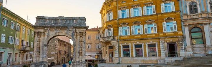 Ein Stadtplatz in Pula, Kroatien, mit historischen Gebäuden.
