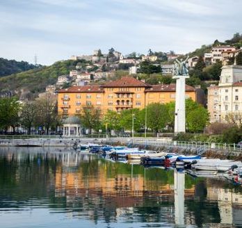 Eine Stadtansicht mit roten Dächern und Blick auf das Meer.