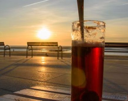 Ein Getränk am Strand bei Sonnenuntergang.