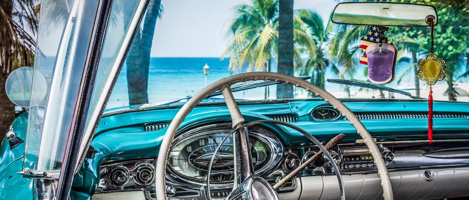 Das Lenkrad eines Oldtimers mit Blick auf die Straße.
