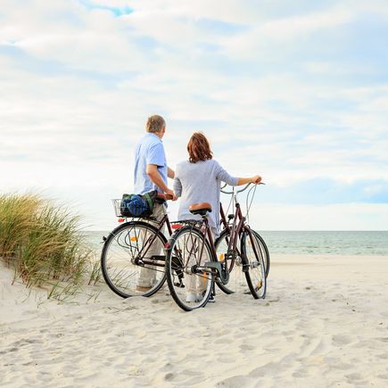 Urlaub an der Ostsee Fehmarn Paar mit Fahrrädern am Strand