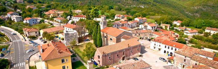 Eine Luftaufnahme einer Stadt mit roten Dächern und Blick auf das Meer.