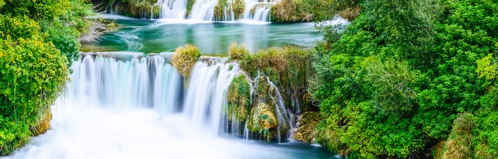 Ein Fluss, der sich durch eine grüne Landschaft schlängelt.
