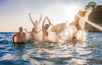 Eine Gruppe von Menschen, die im Meer planscht.