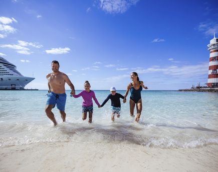 FAmilie läuft am Strand mit MSC Kreuzfahrtschiff im Hintergrund