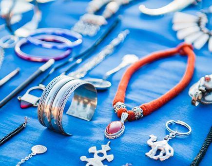 Verschiedener Schmuck auf blauem Tuch ausgelegt