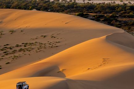 Eine Sanddüne in der Wüste bei Sonnenuntergang.