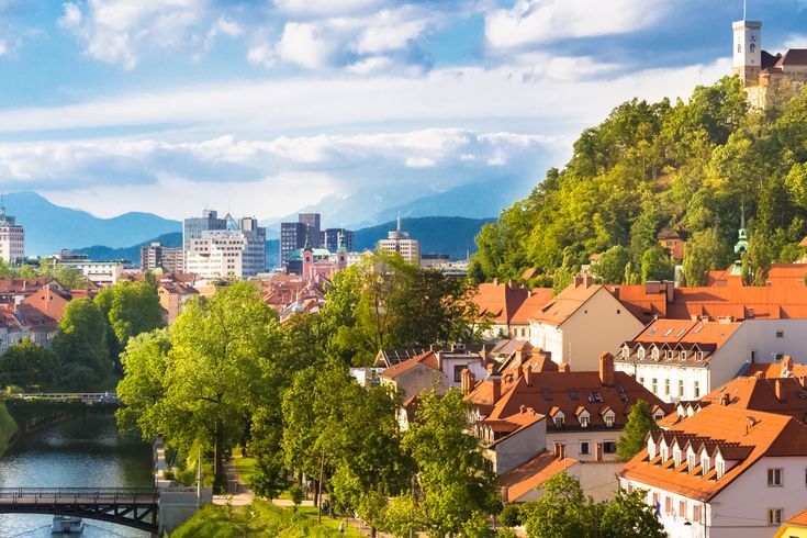 Eine Stadtansicht von Ljubljana, Slowenien, mit einem Fluss und bunten Gebäuden.