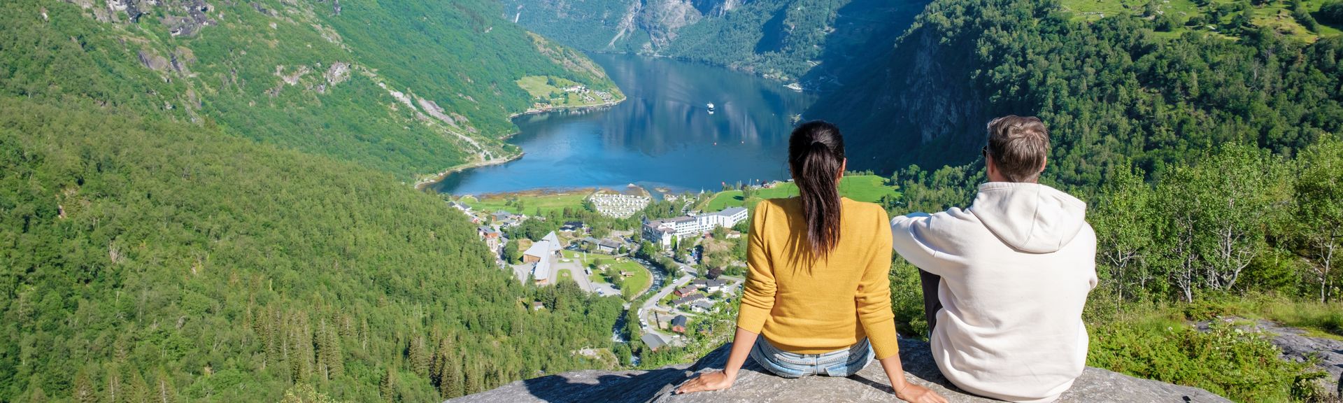 Paar sitzt auf Berg und schaut in die Ferne