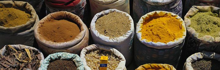 Bunte Gewürzsäcke voller duftender Kräuter, Samen und Pulver verwandeln den Markt in ein aromatisches Farbenmeer.