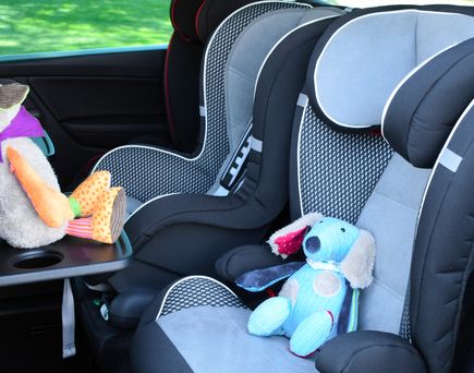 Blick auf die Rückband eines Autos, mit Kindersitzen und Kuscheltieren.