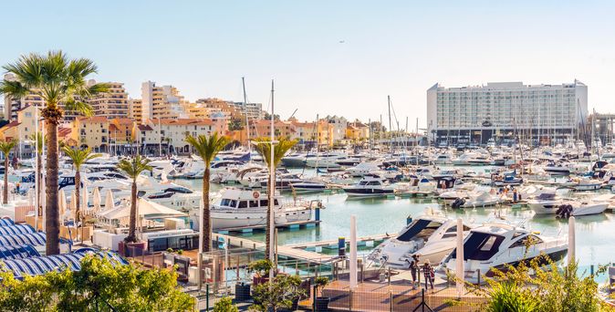 Blick auf einen kleinen Hafen in Faro. Boote und Palmen