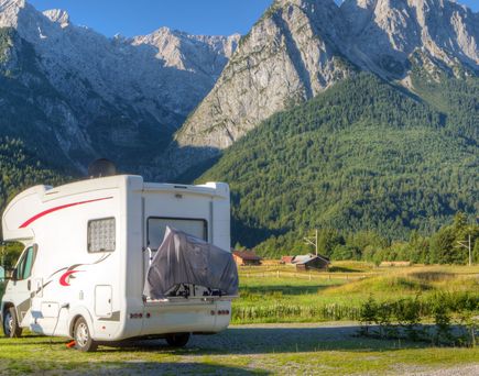 Ein weißes Wohnmobil parkt auf einem Campingplatz.
