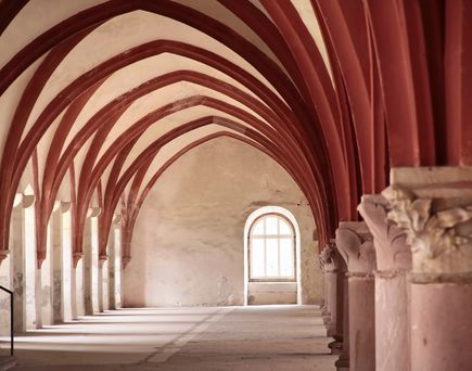 Ein gewölbter Gang in einem Kloster oder einer historischen Anlage.