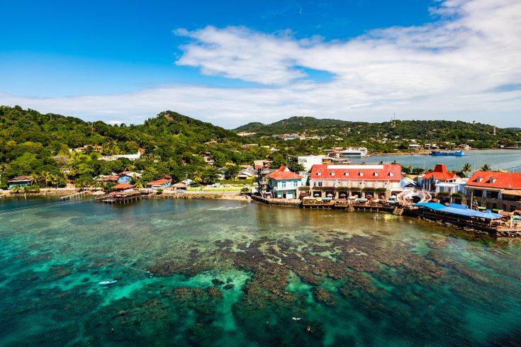 Blick auf die Paradiesische Küste von Roatan, Honduras mit bunten Häusern am Hafen