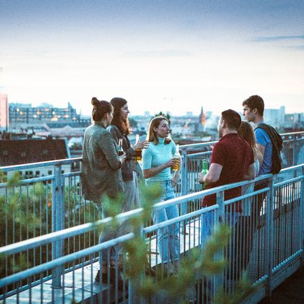 Berlin Nachtleben Städtereisen Urlaub Gruppe junger Menschen auf Dachterrasse
