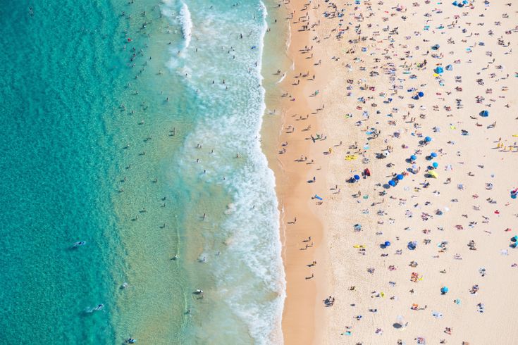 Strand mit vielen Strandbesuchern und hellblauem Meer in Australien 