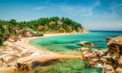 Eine Bucht mit türkisblauem Wasser und einem Strand.