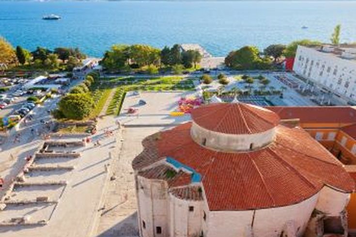 Eine Luftaufnahme der Altstadt von Zadar, Kroatien, mit roten Dächern und dem Meer.