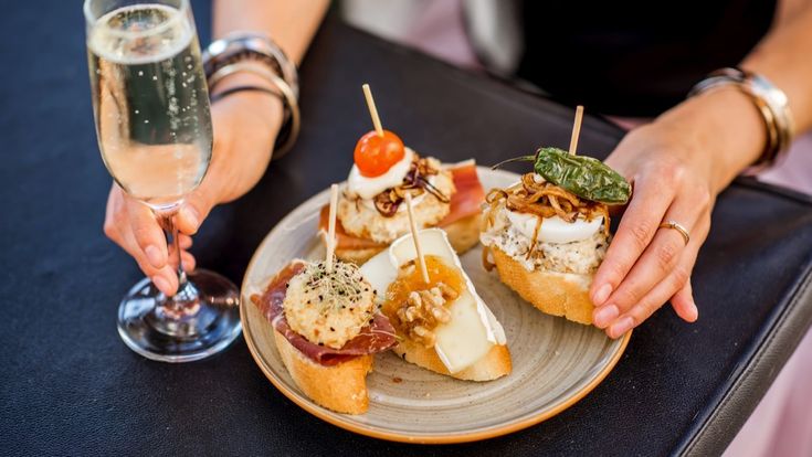 Eine Platte mit Tapas und einem Glas Wein.
