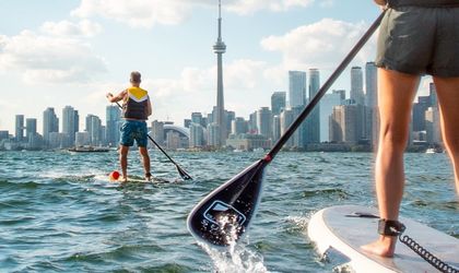 Stand Up Paddle Fahrer auf dem Lake Ontario vor der Skyline von Toronto mit dem CN Tower