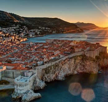 Eine Luftaufnahme von Dubrovnik, Kroatien, mit der Altstadt und dem Meer bei Sonnenuntergang.