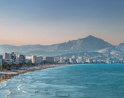 Strand von Alicante in Spanien mit Hochhäusern und Bergpanorama