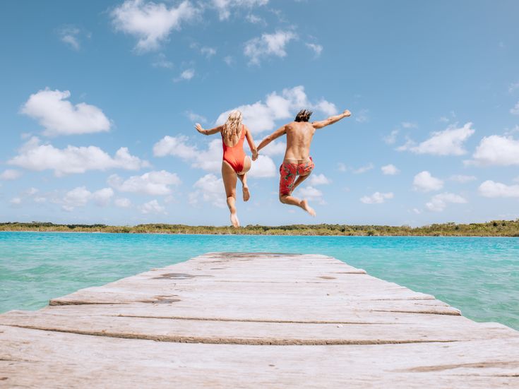 Paar läuft über einen Steg auf das Meer zu