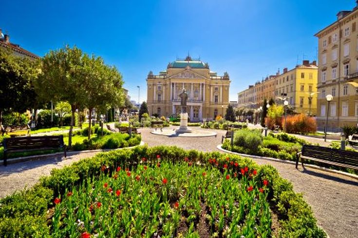 Ein Platz mit einem Brunnen und einem historischen Gebäude.