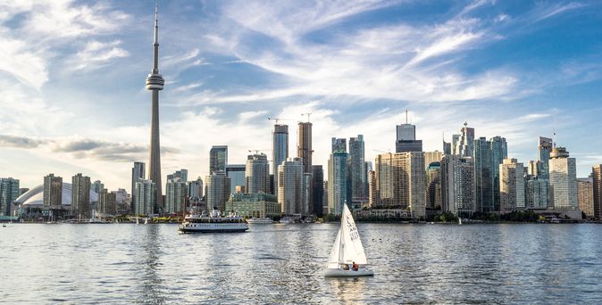 Blick auf Toronto und den CN Tower vom Wasser aus, Boote im Vordergrund